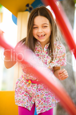 Cute little girl is playing in playground