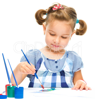 Little girl is painting with gouache