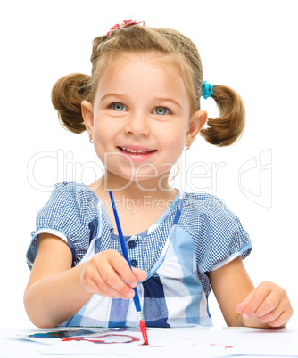 Little girl is painting with gouache