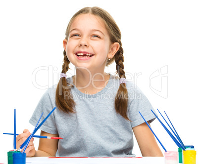 Little girl is painting with gouache