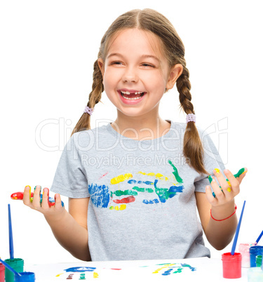 Portrait of a cute girl playing with paints