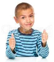 Portrait of a cute boy showing thumb up sign