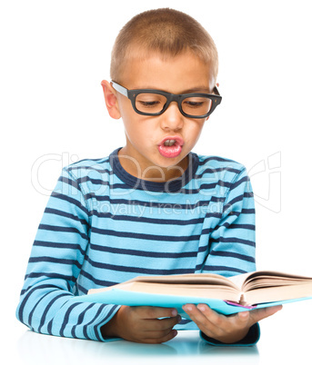 Little boy is reading a book