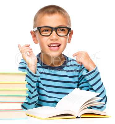 Young boy is daydreaming while reading book