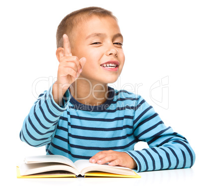 Little boy is reading a book