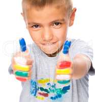 Portrait of a cute boy playing with paints