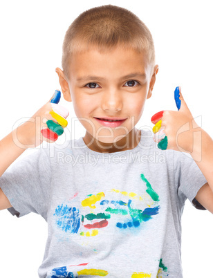 Portrait of a cute boy playing with paints