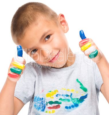 Portrait of a cute boy playing with paints