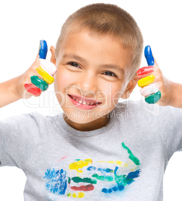 Portrait of a cute boy playing with paints