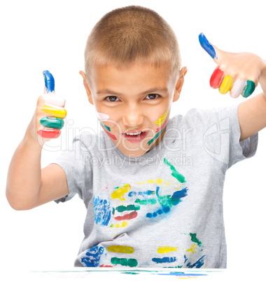 Portrait of a cute boy playing with paints