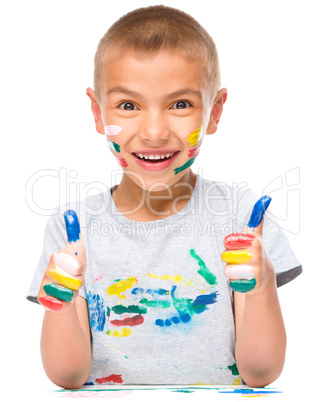 Portrait of a cute boy playing with paints