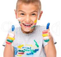 Portrait of a cute boy playing with paints