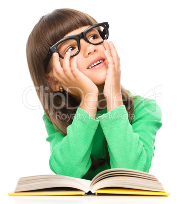 Young girl is daydreaming while reading book