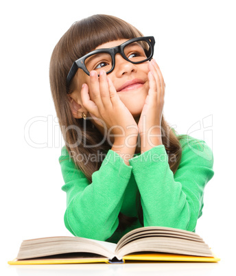 Young girl is daydreaming while reading book