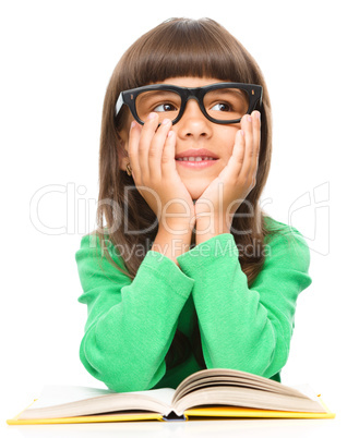 Young girl is daydreaming while reading book