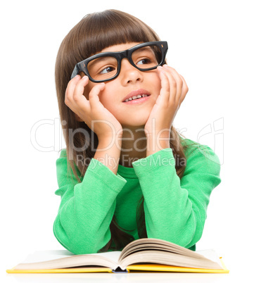 Young girl is daydreaming while reading book