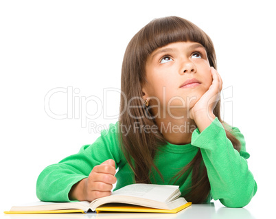 Young girl is daydreaming while reading book