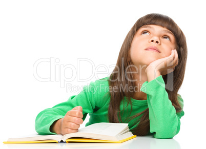 Young girl is daydreaming while reading book