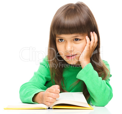 Young girl is daydreaming while reading book