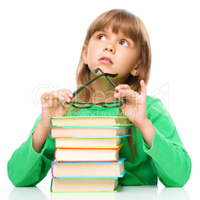 Young girl is daydreaming while reading book