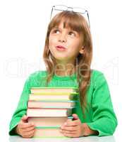 Young girl is daydreaming while reading book
