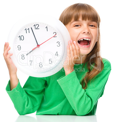 Little girl is holding big clock