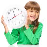 Little girl is holding big clock