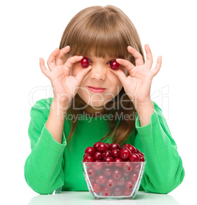 Cute girl is eating cherries