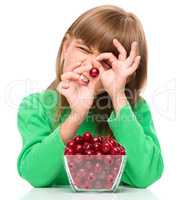 Cute girl is eating cherries