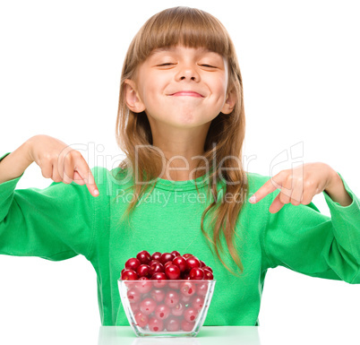 Cute girl is eating cherries