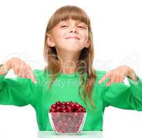 Cute girl is eating cherries