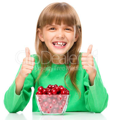 Cute girl is eating cherries