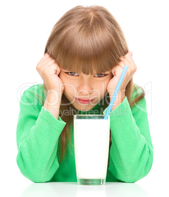Gloomy little girl doesn't want to drink milk