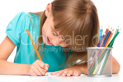 Little girl is drawing using pencils