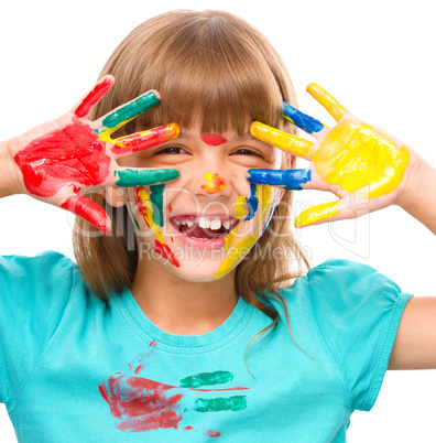 Portrait of a cute girl playing with paints