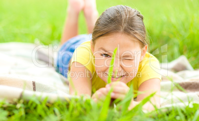 Portrait of a little girl laying on green grass