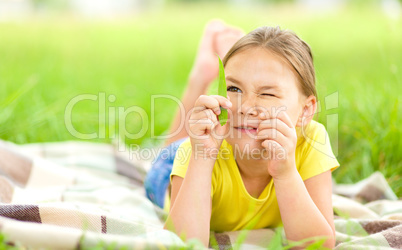 Portrait of a little girl laying on green grass