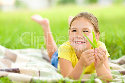 Portrait of a little girl laying on green grass