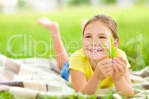Portrait of a little girl laying on green grass