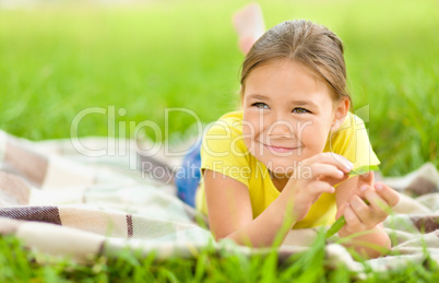 Portrait of a little girl laying on green grass