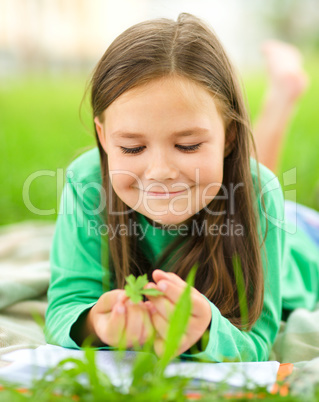 Portrait of a little girl laying on green grass