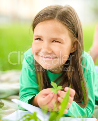 Portrait of a little girl laying on green grass