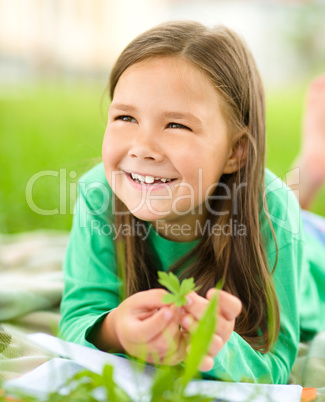 Portrait of a little girl laying on green grass