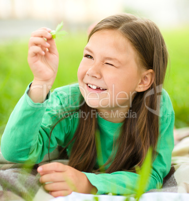 Portrait of a little girl laying on green grass