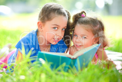 Two little girls are reading book