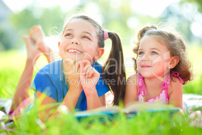 Two little girls are reading book