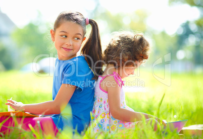 Two little girls are reading books