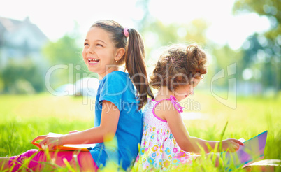 Two little girls are reading books