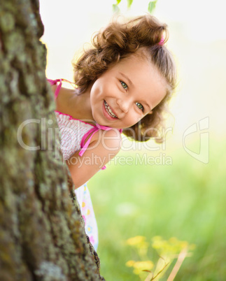Cute little girl is playing hide and seek