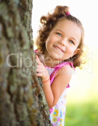 Cute little girl is playing hide and seek